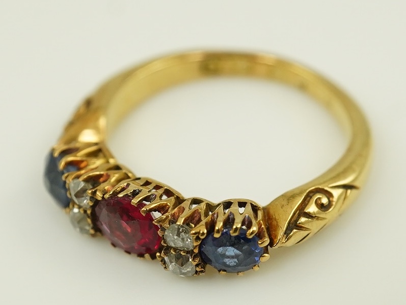 An early 20th century gold, ruby, sapphire and diamond cluster set half hoop ring